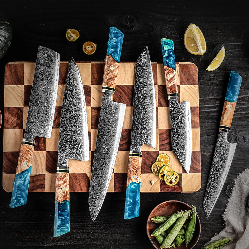 Set of knives with wooden handles on a checkered cutting board with lemon slices.