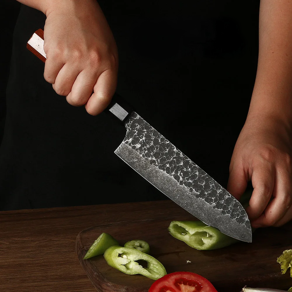 Cuțit Santoku în mâinile unui bucătar profesionist care feliază ardei
