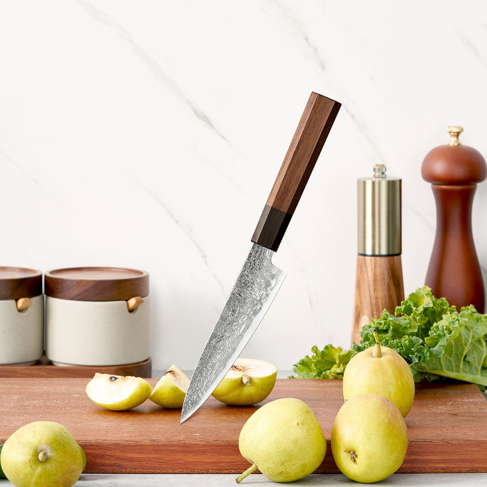Chef's knife with wooden handle on a cutting board with apples and vegetables