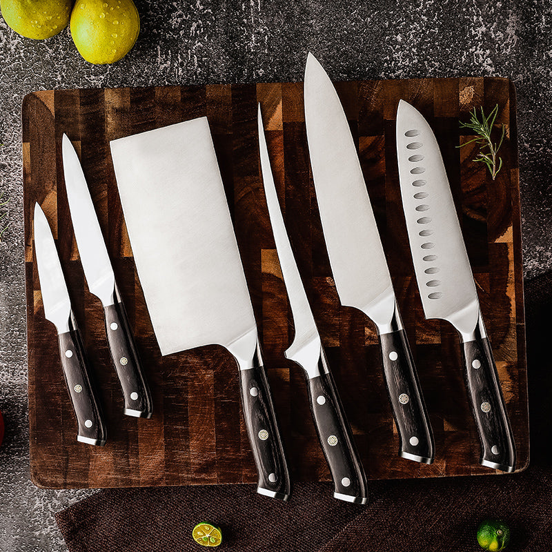 Set of german steel Hikari kitchen knives on a wooden cutting board with fruits in the background