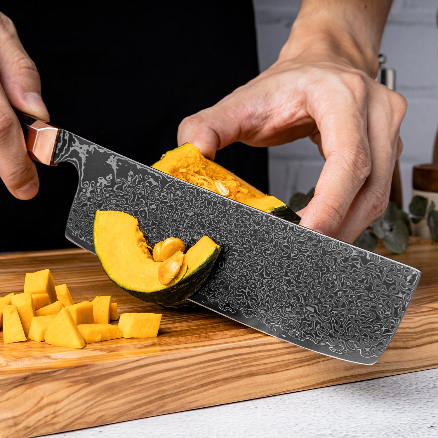 Person using a decorative knife, a nakiri vegetable knife to cut a squash on a wooden cutting board.