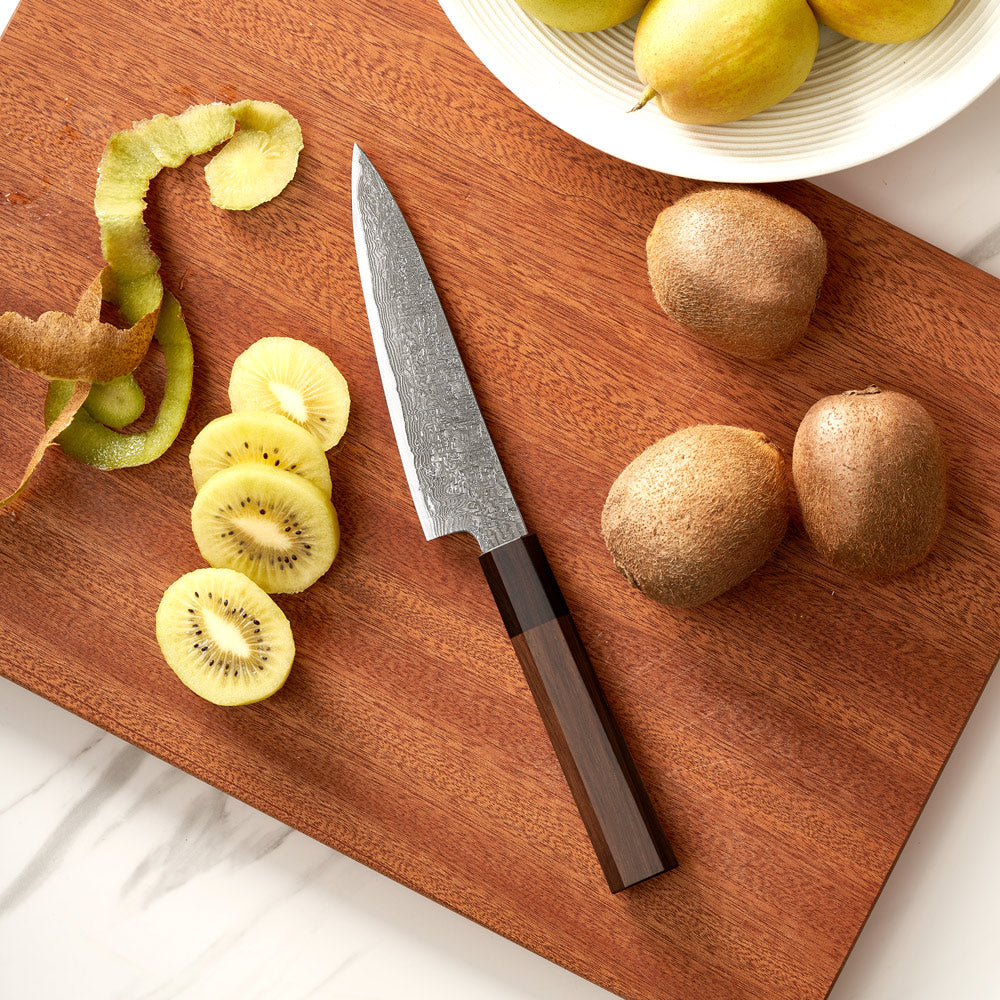 Sliced kiwis on a wooden cutting board with a knife